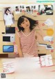 A woman in a red and white striped shirt is posing for a magazine.