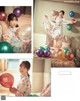 A woman sitting on a couch holding a bunch of balloons.