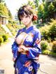 A woman in a blue kimono posing for a picture.