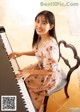 A woman sitting on a chair playing a piano.