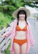 A woman in an orange bikini and a straw hat.